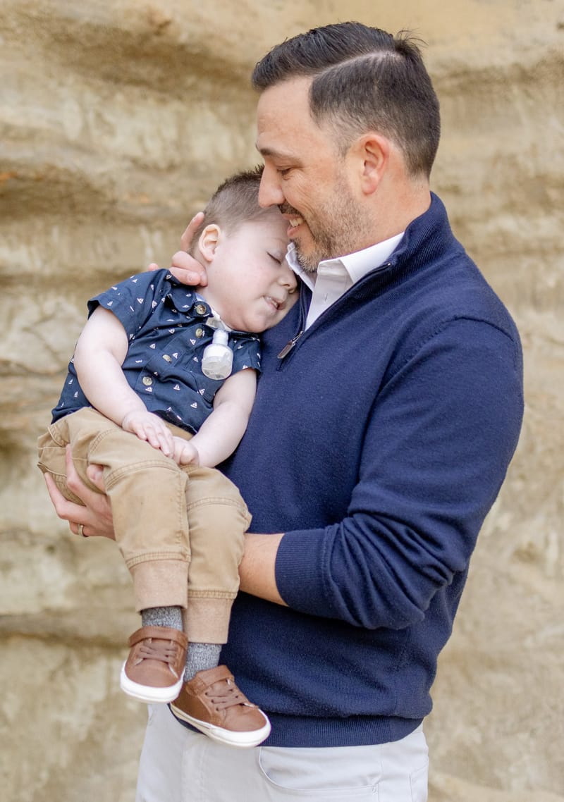 James, a young child, resting in his father's arms.