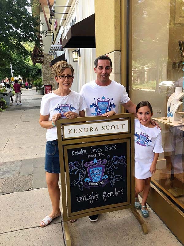 Addie and her parents at a fundraising event for Addie's Tale.