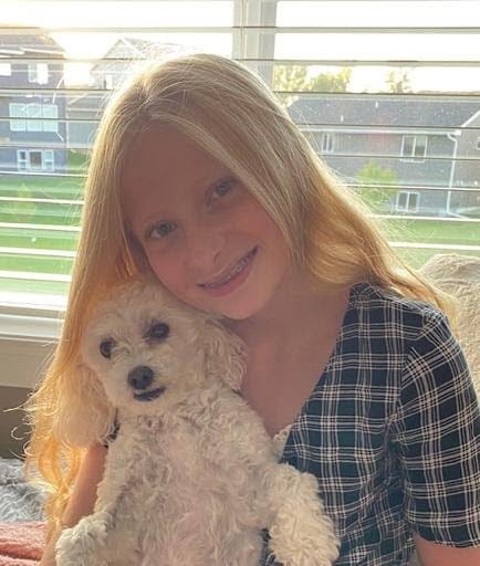 Alana holding her small white dog.