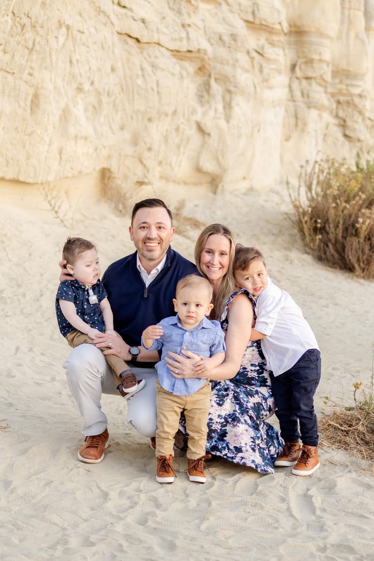 James with his parents and two brothers, a family portrait outdoors.