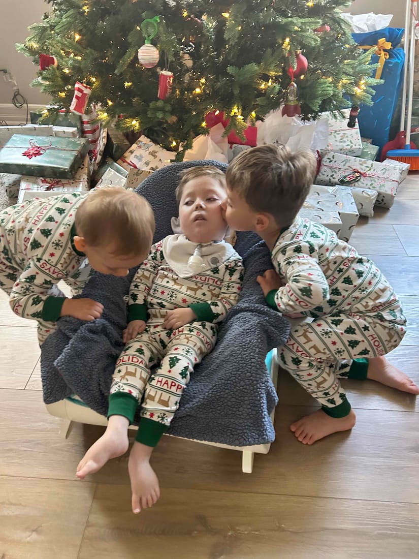 James with his two brothers in matching holiday pajamas.