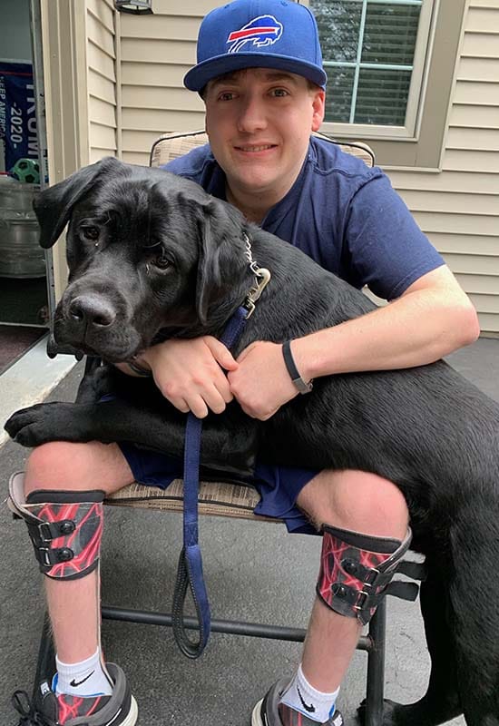 Zach's black Labrador resting on his lap.
