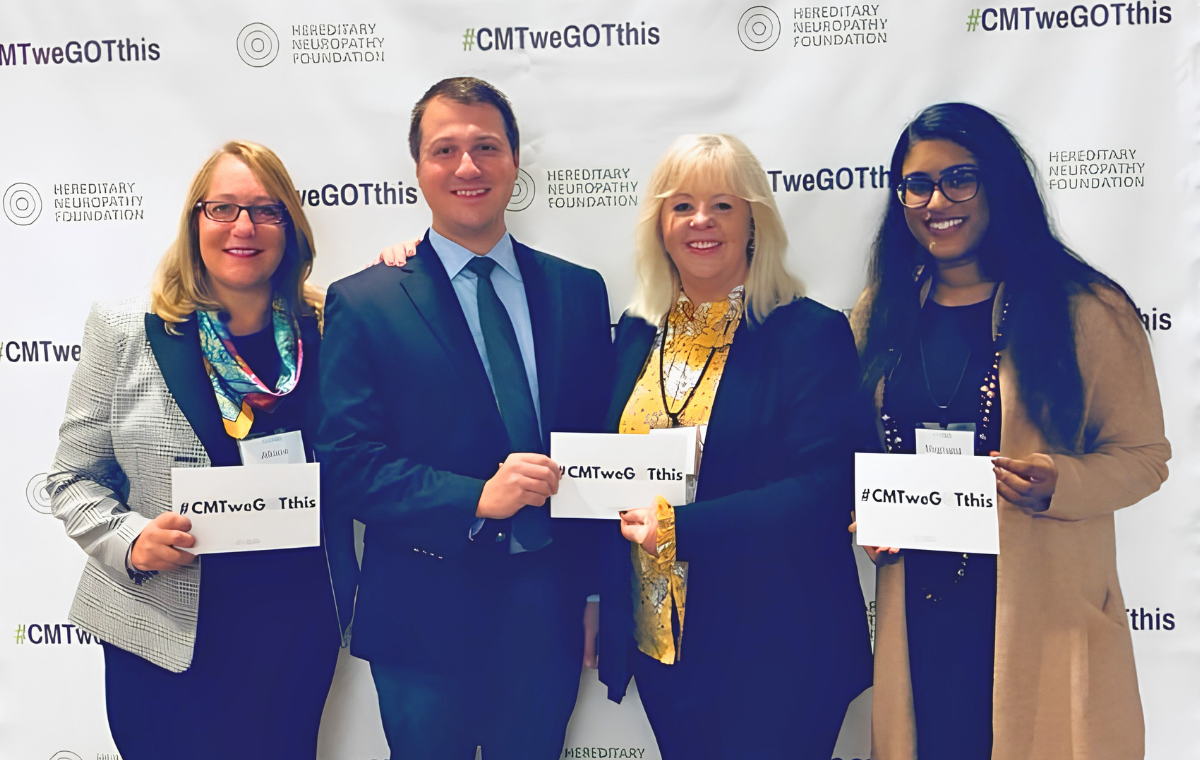 Four HNF advocates standing in front of a Hereditary Neuropathy Foundation step-and-repeat backdrop, each holding a hashtag CMT we GOT this card.