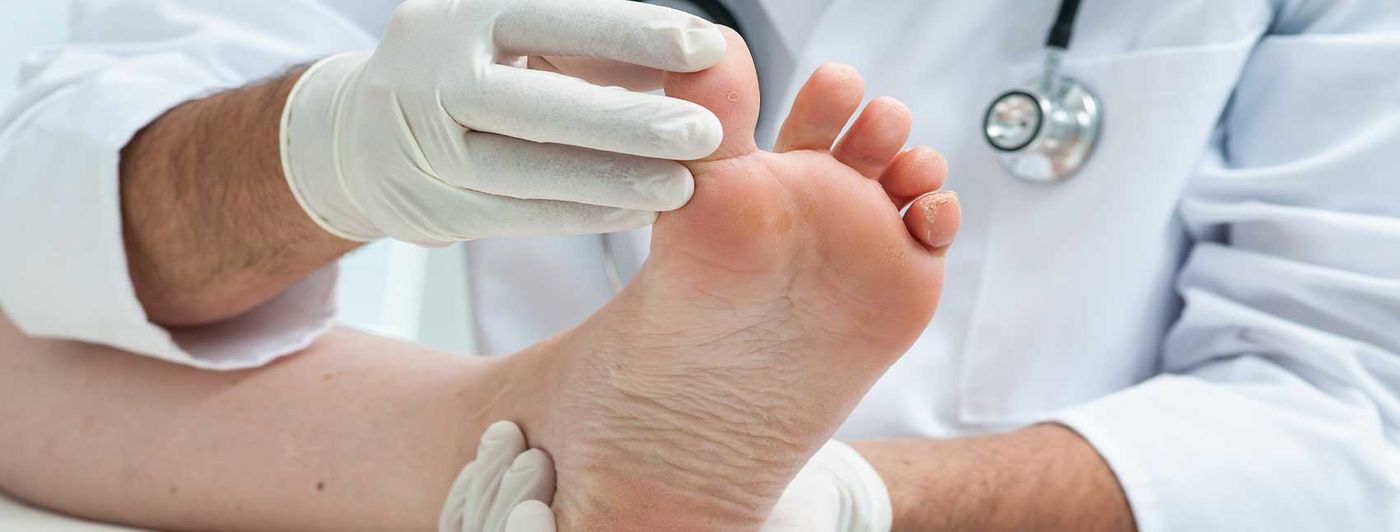A podiatrist examining a patient's foot and ankle during a clinic visit.
