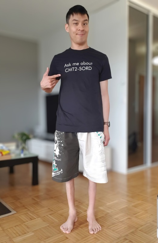 A smiling young man points at his t-shirt, which reads: Ask me about CMT2-SORD.