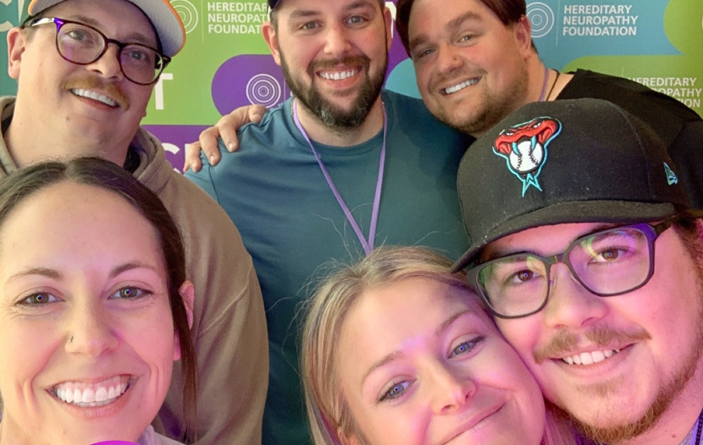 Six smiling attendees crowded together for a selfie at the summit.
