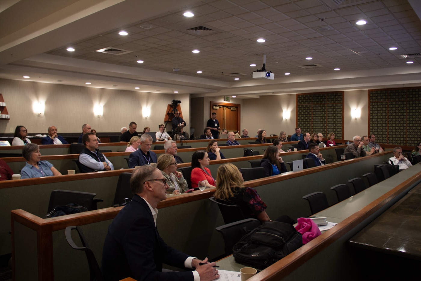 Attendees seated in a conference hall during a summit session.