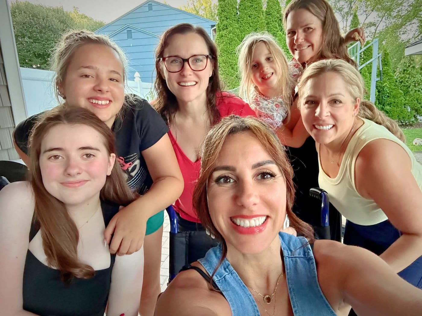 A joyful group selfie of Team CMT women and girls at a community gathering.