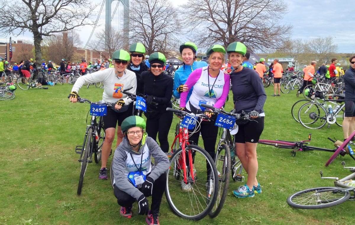 Team CMT riders in green helmet covers pose with their bikes at a five-borough bike tour.