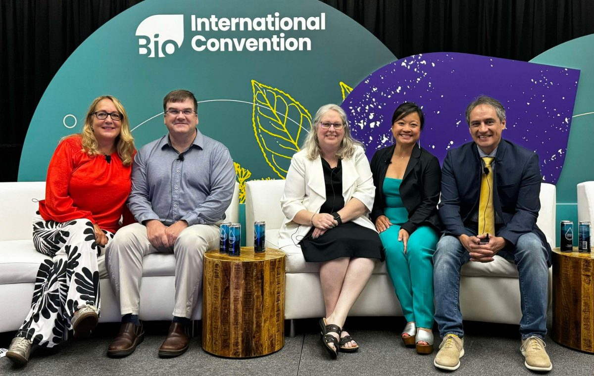 Five people seated together on white couches on stage in front of a BIO International Convention backdrop, at a biotech industry panel.