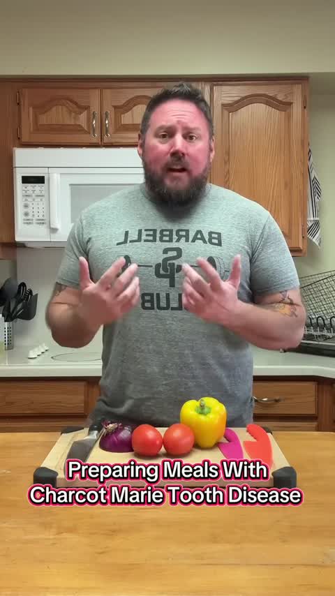 Un hombre está de pie frente a una tabla de cortar en la cocina, con verduras frescas, listo para cocinar.